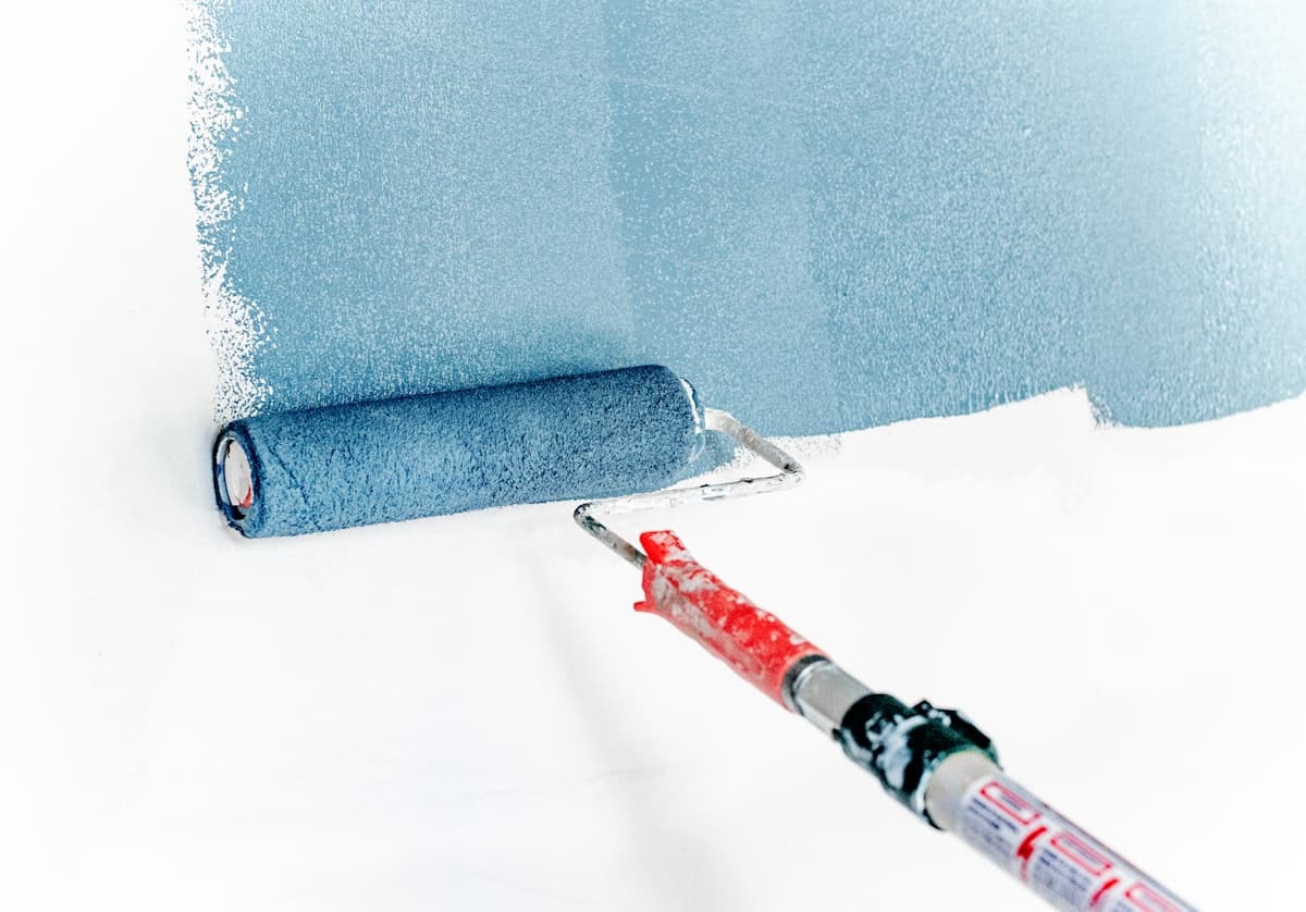 Roller applying coating to a wall